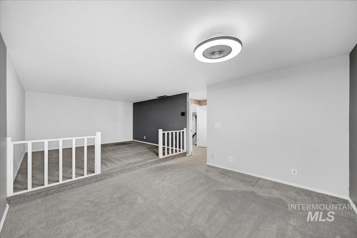Empty room featuring carpet flooring and baseboards