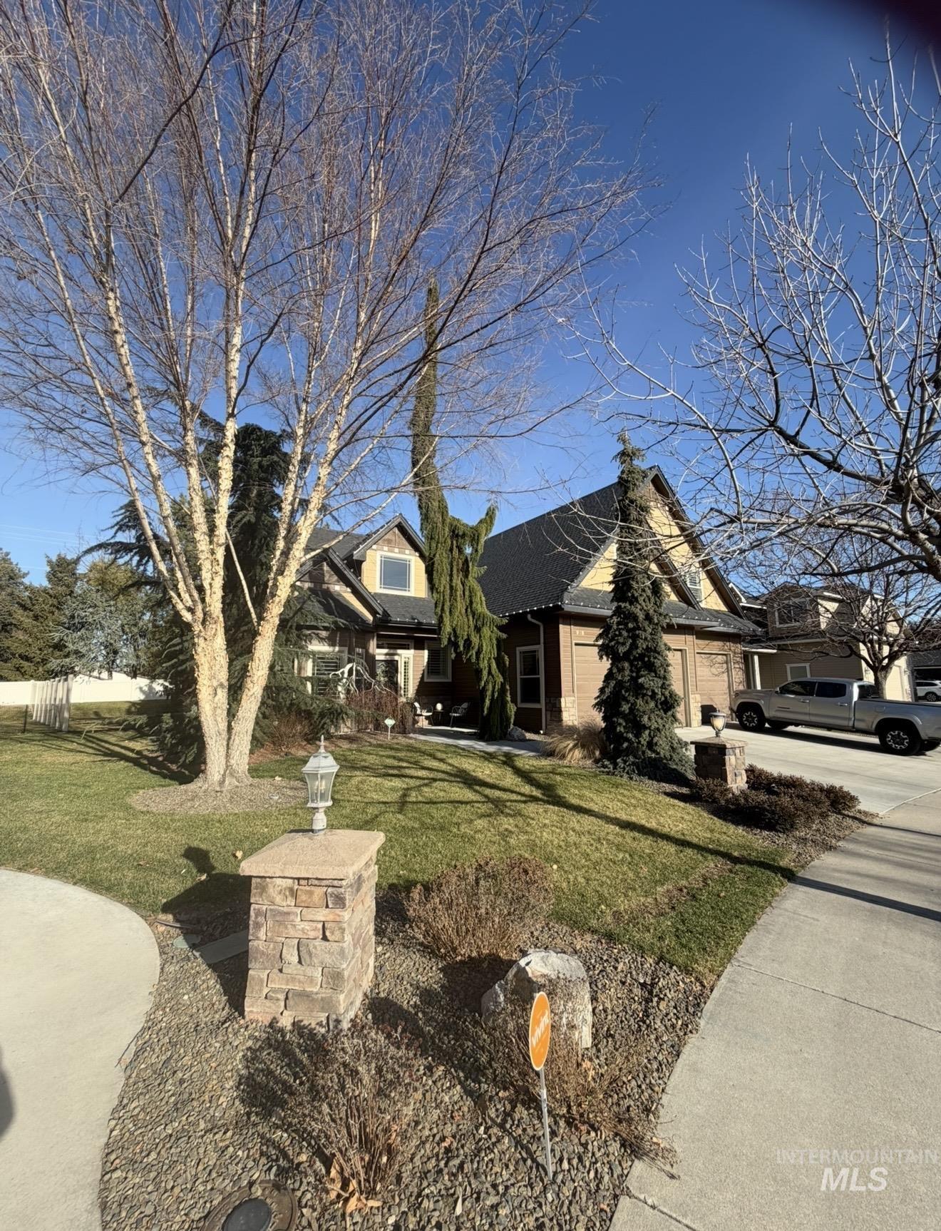 View of front of home with a front yard, brick siding, and a garage