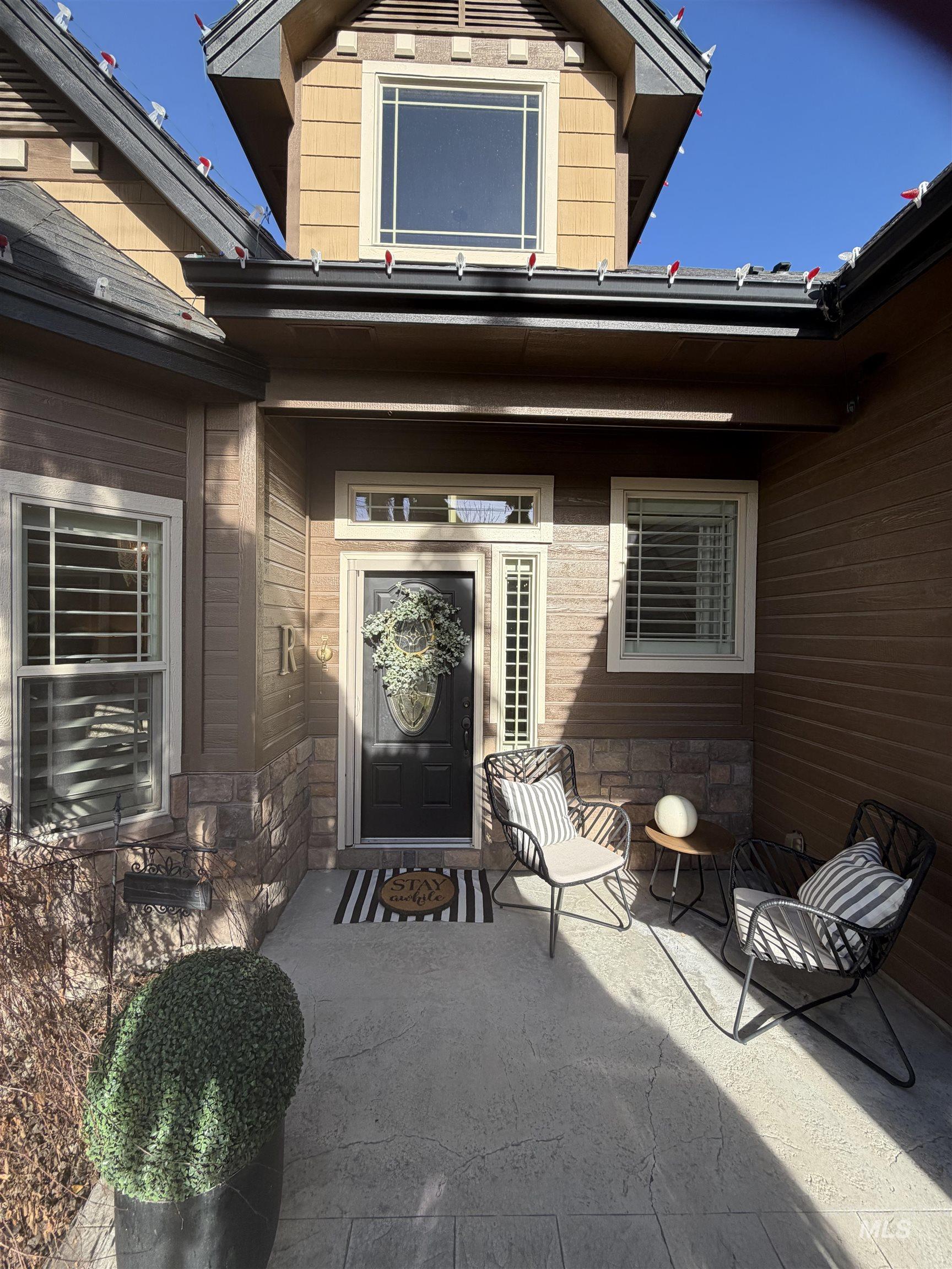 Doorway to property featuring stone siding and a patio area