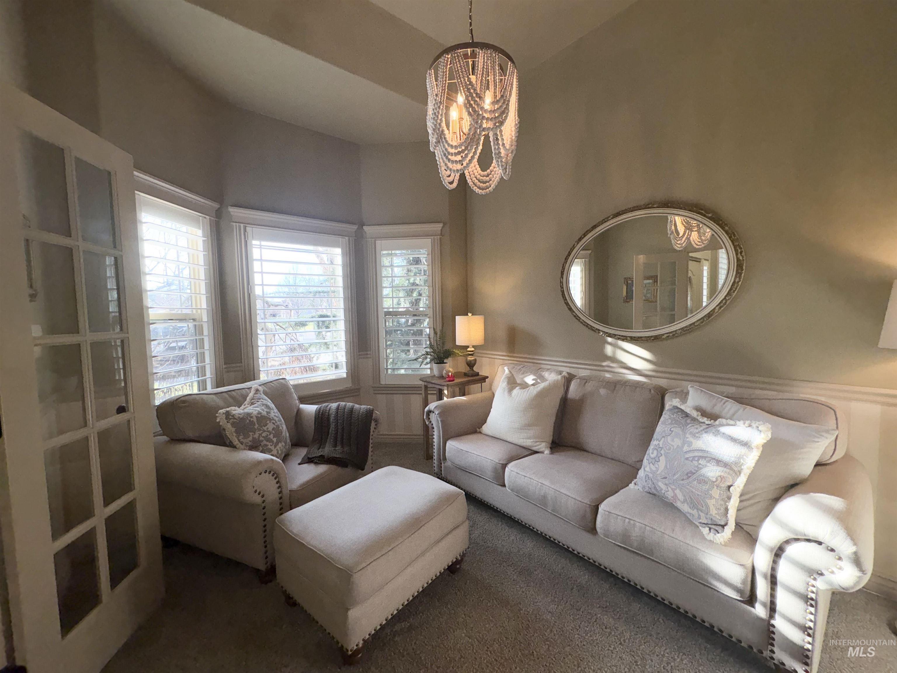 Living room with carpet floors and a chandelier