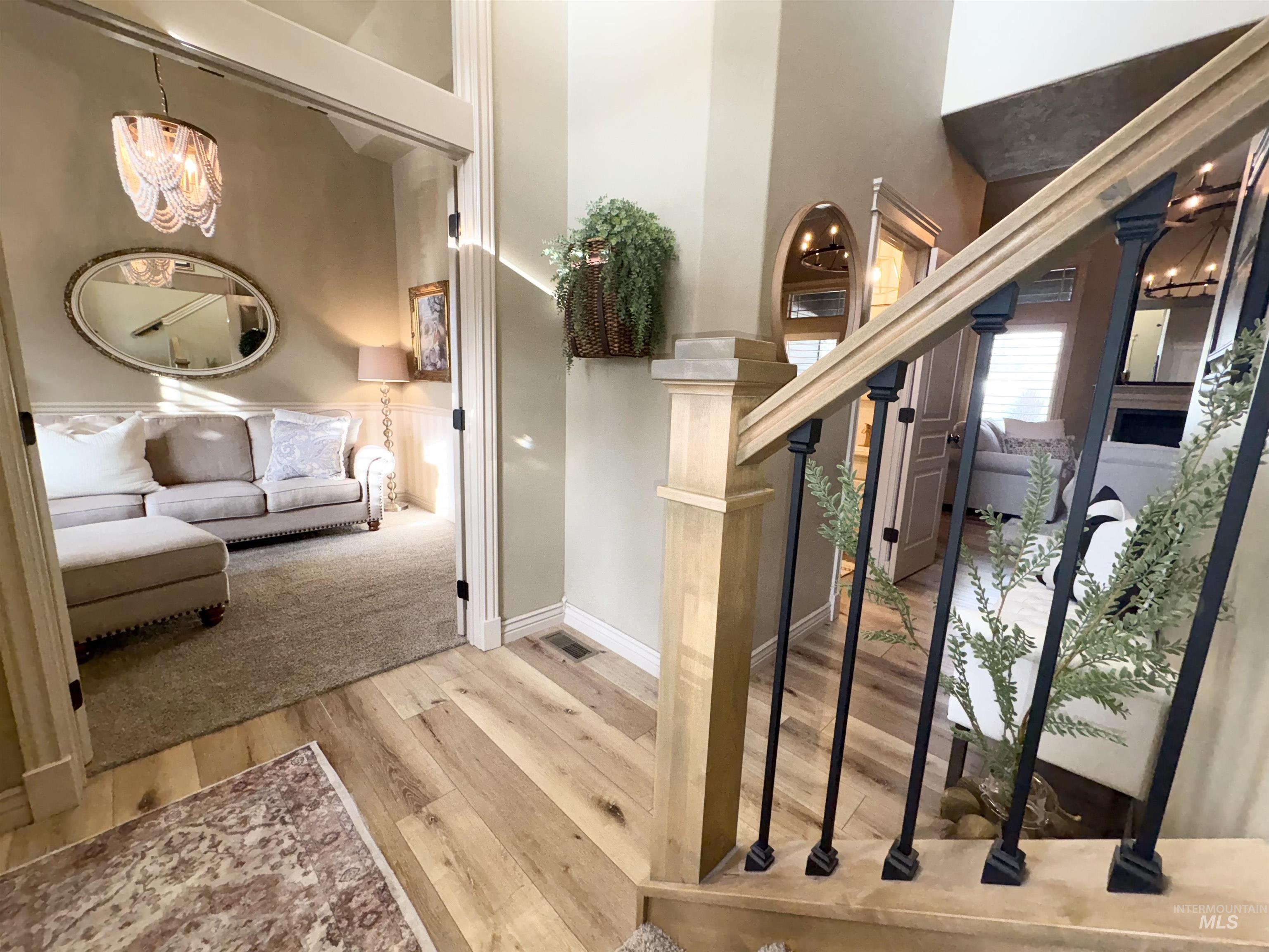Stairway with a chandelier, a towering ceiling, and hardwood / wood-style flooring