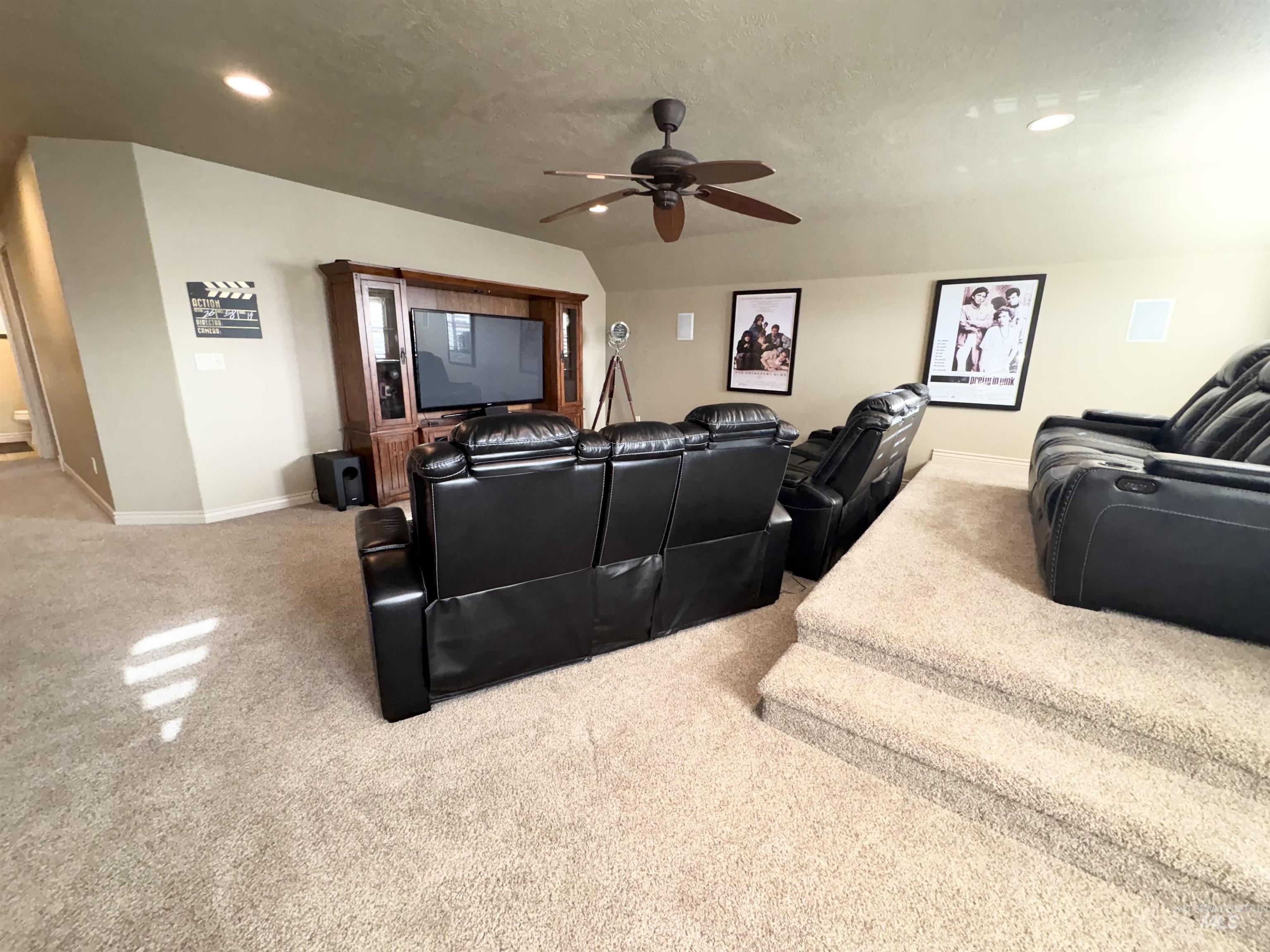 Home theater featuring light colored carpet, a ceiling fan, recessed lighting, and a textured ceiling