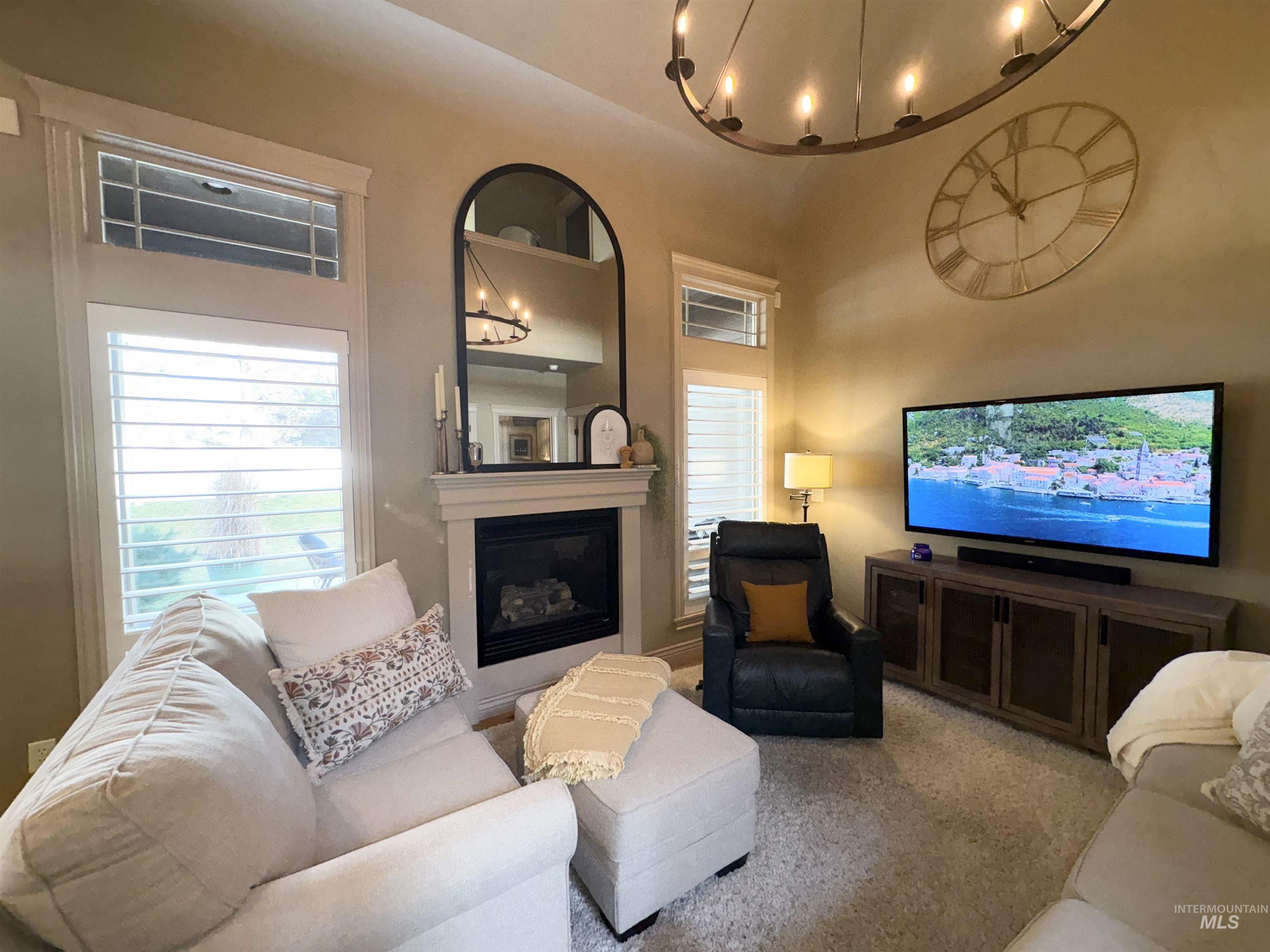 Living room featuring a glass covered fireplace and a high ceiling