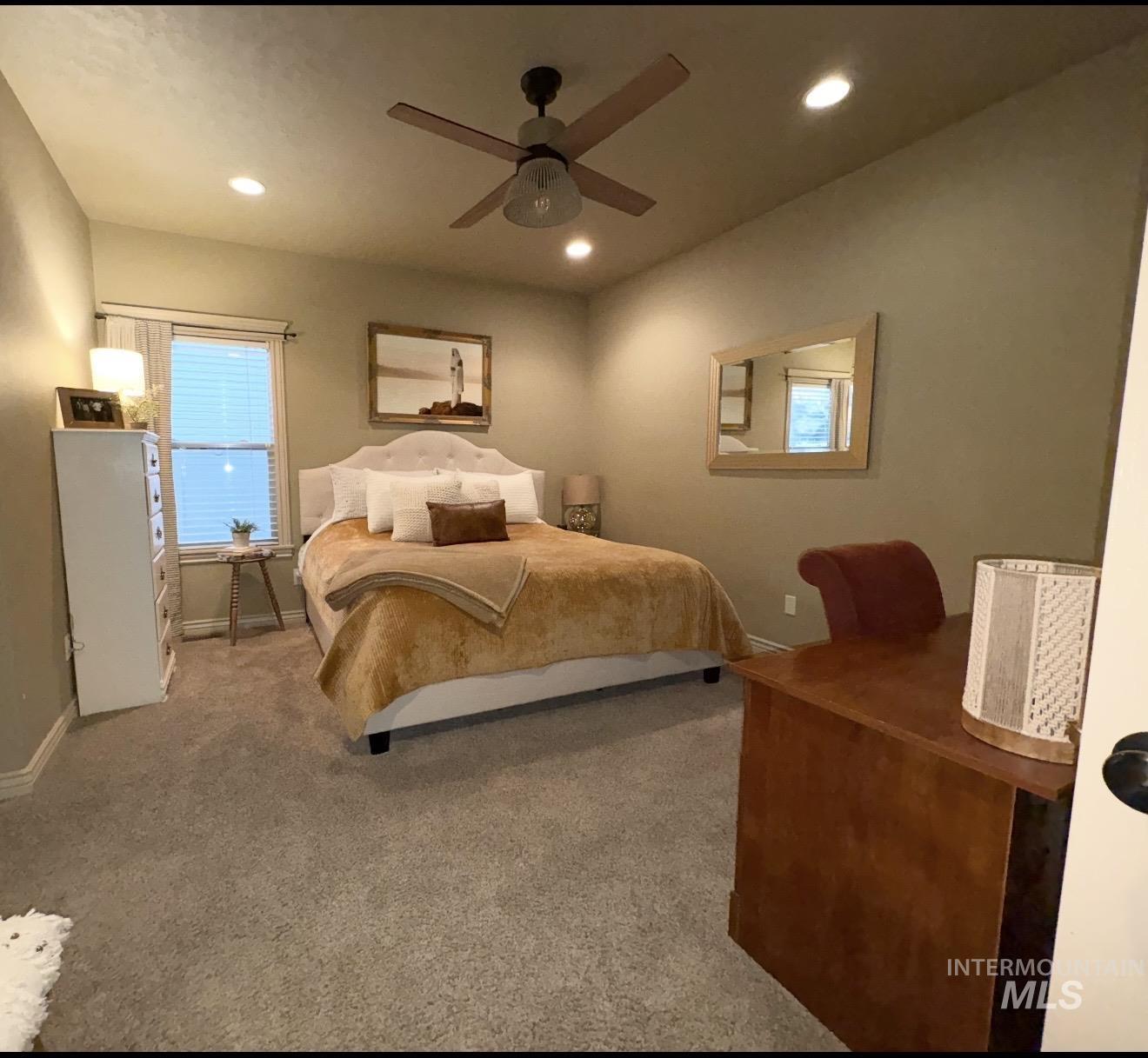 Carpeted bedroom with a ceiling fan and recessed lighting