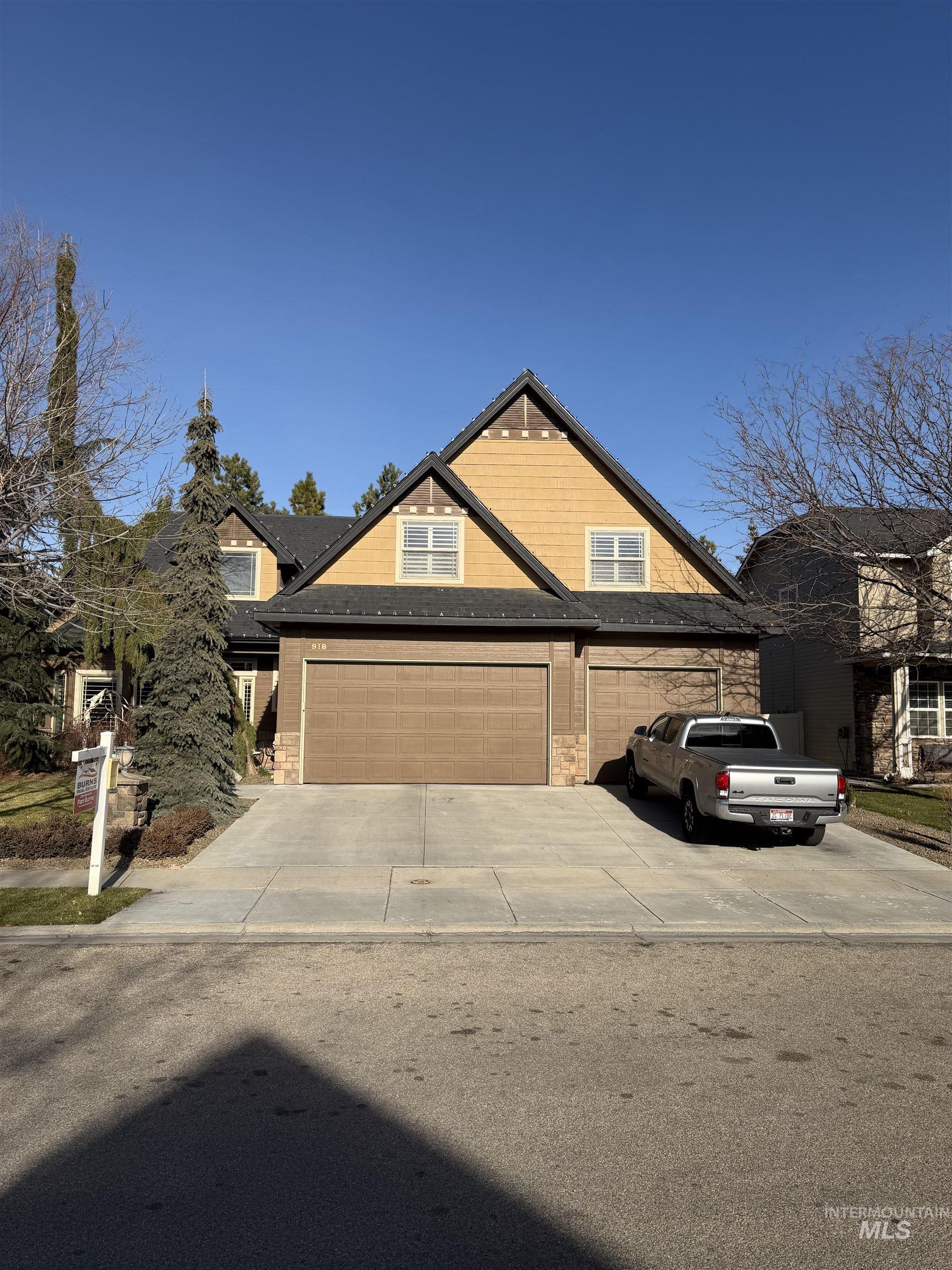 View of front facade with a garage, concrete driveway, and stone siding