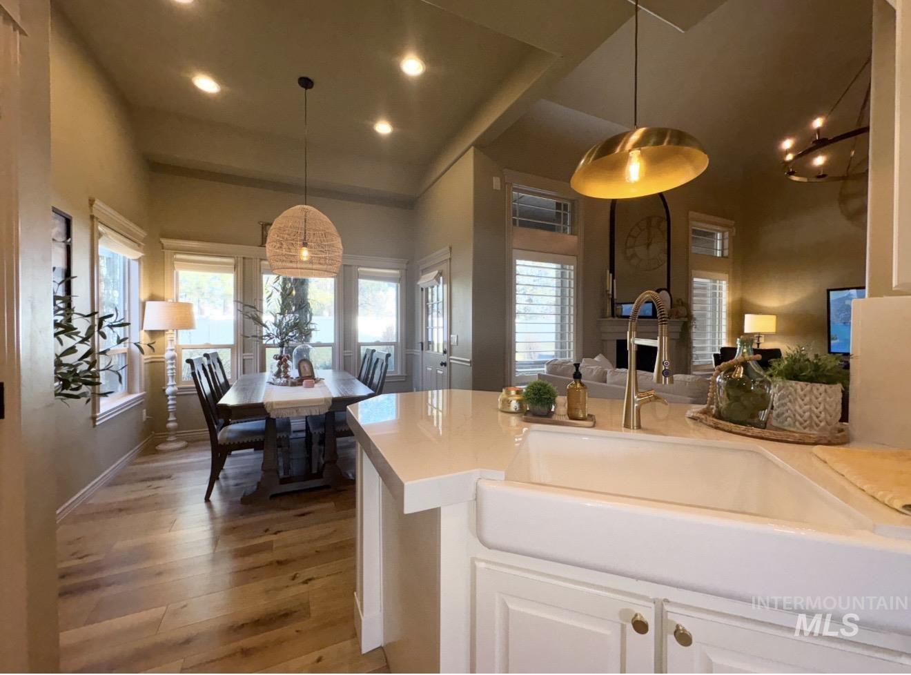 Kitchen featuring white cabinetry, recessed lighting, light wood-style floors, plenty of natural light, and decorative light fixtures