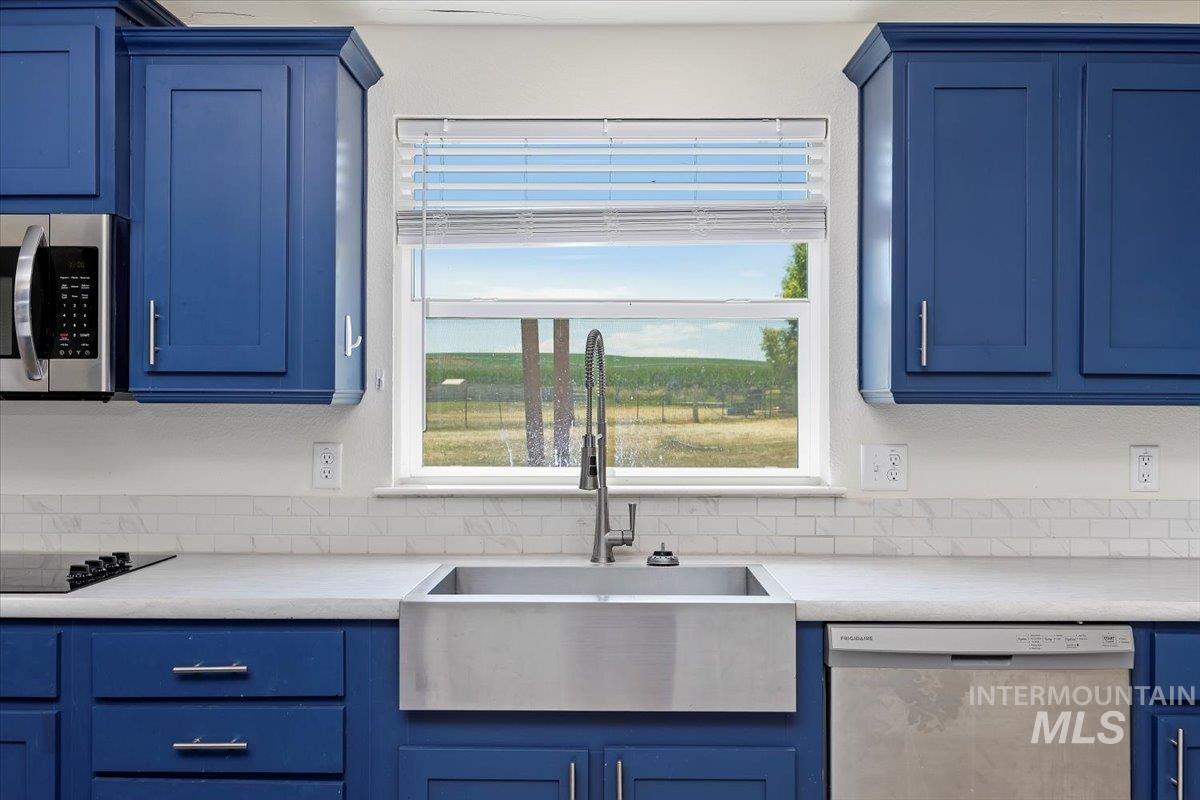 Kitchen featuring blue cabinets and appliances with stainless steel finishes