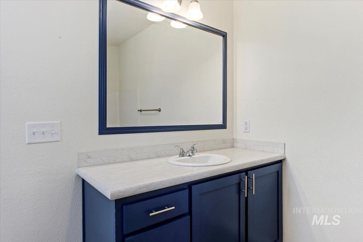 Bathroom featuring vanity and a textured wall