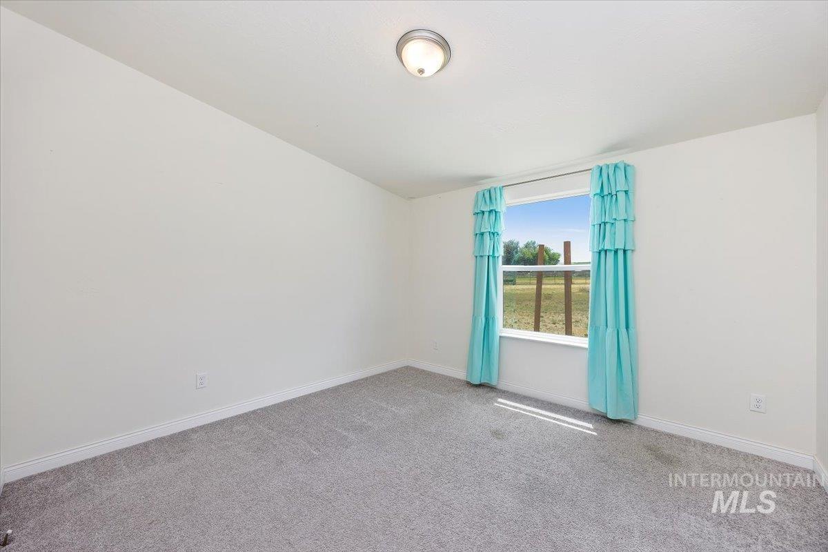 Unfurnished room with carpet and baseboards