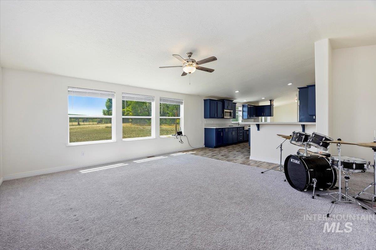 Living room with light carpet and a ceiling fan
