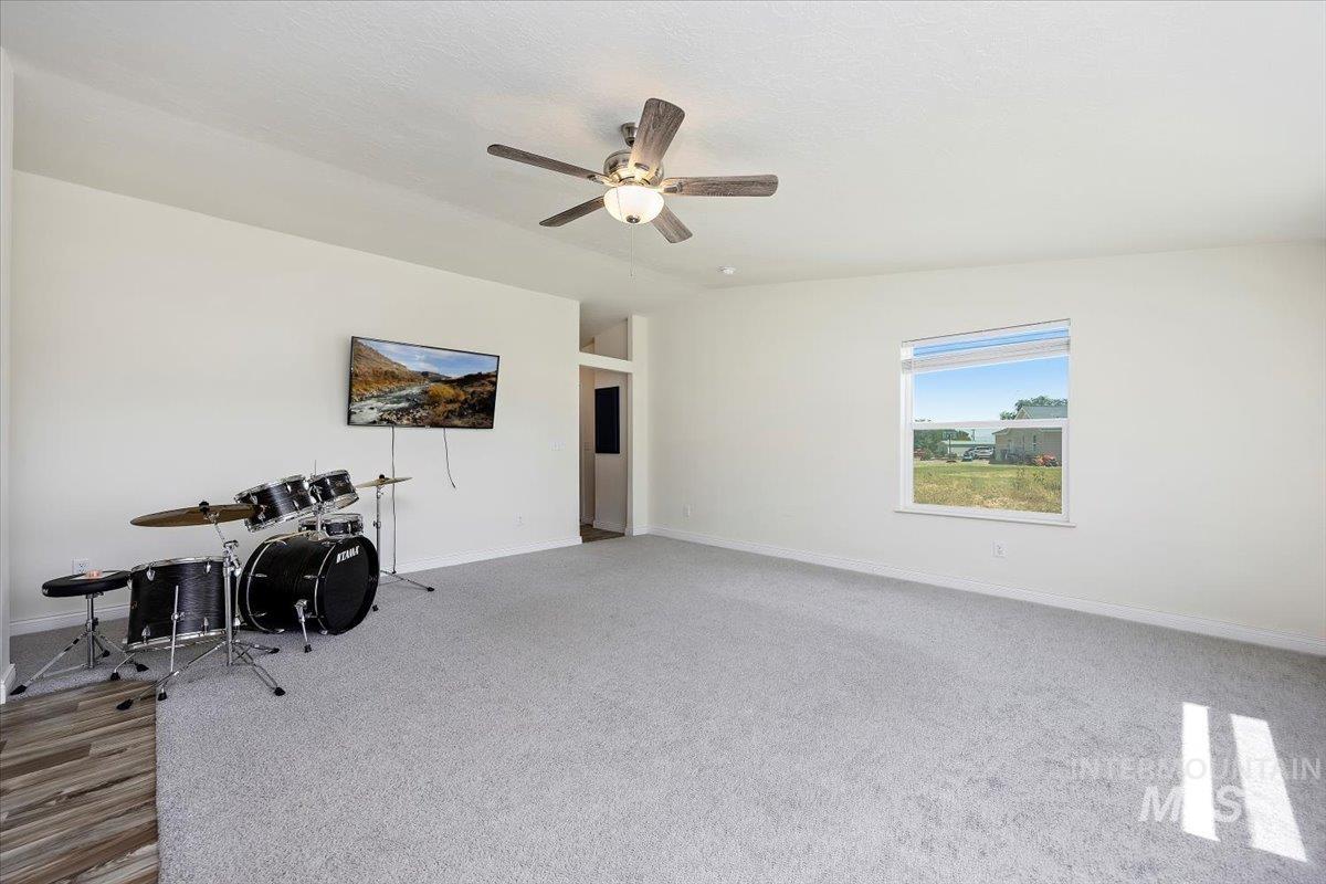 Interior space featuring carpet floors, ceiling fan, and lofted ceiling