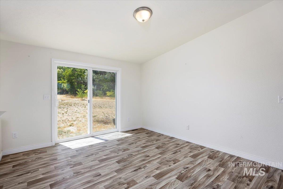 Spare room featuring light wood finished floors and baseboards