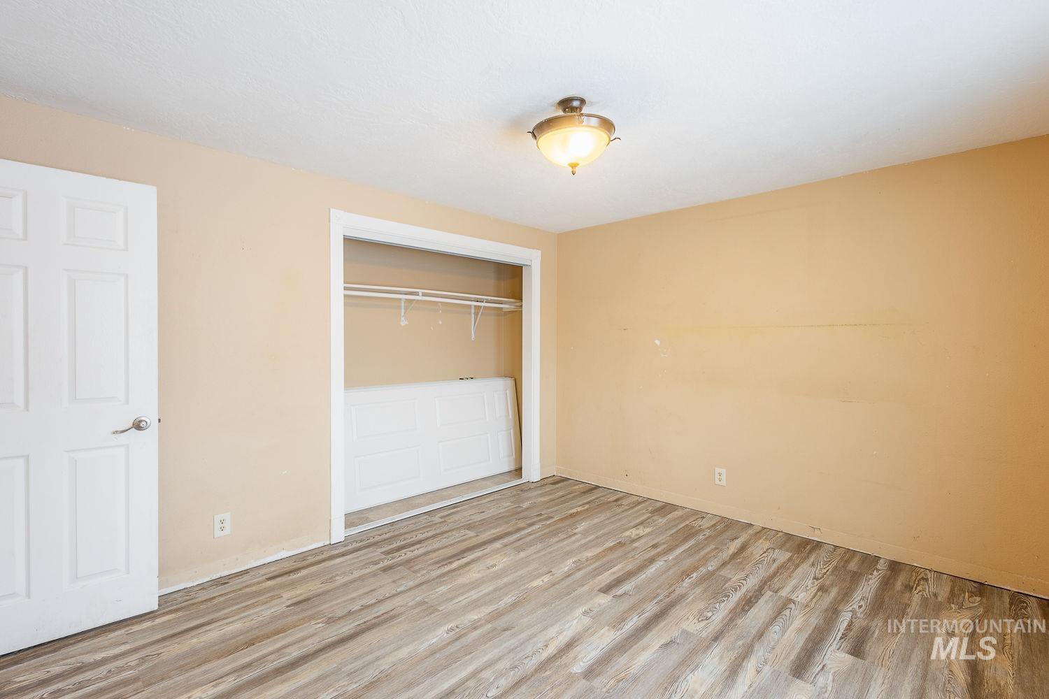 Unfurnished bedroom with a closet and wood finished floors