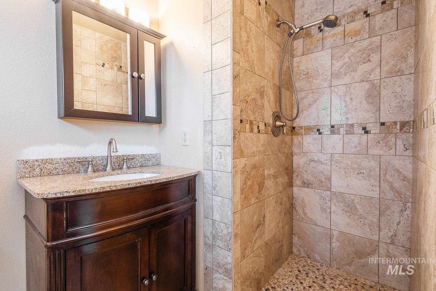 Bathroom featuring vanity and a shower stall