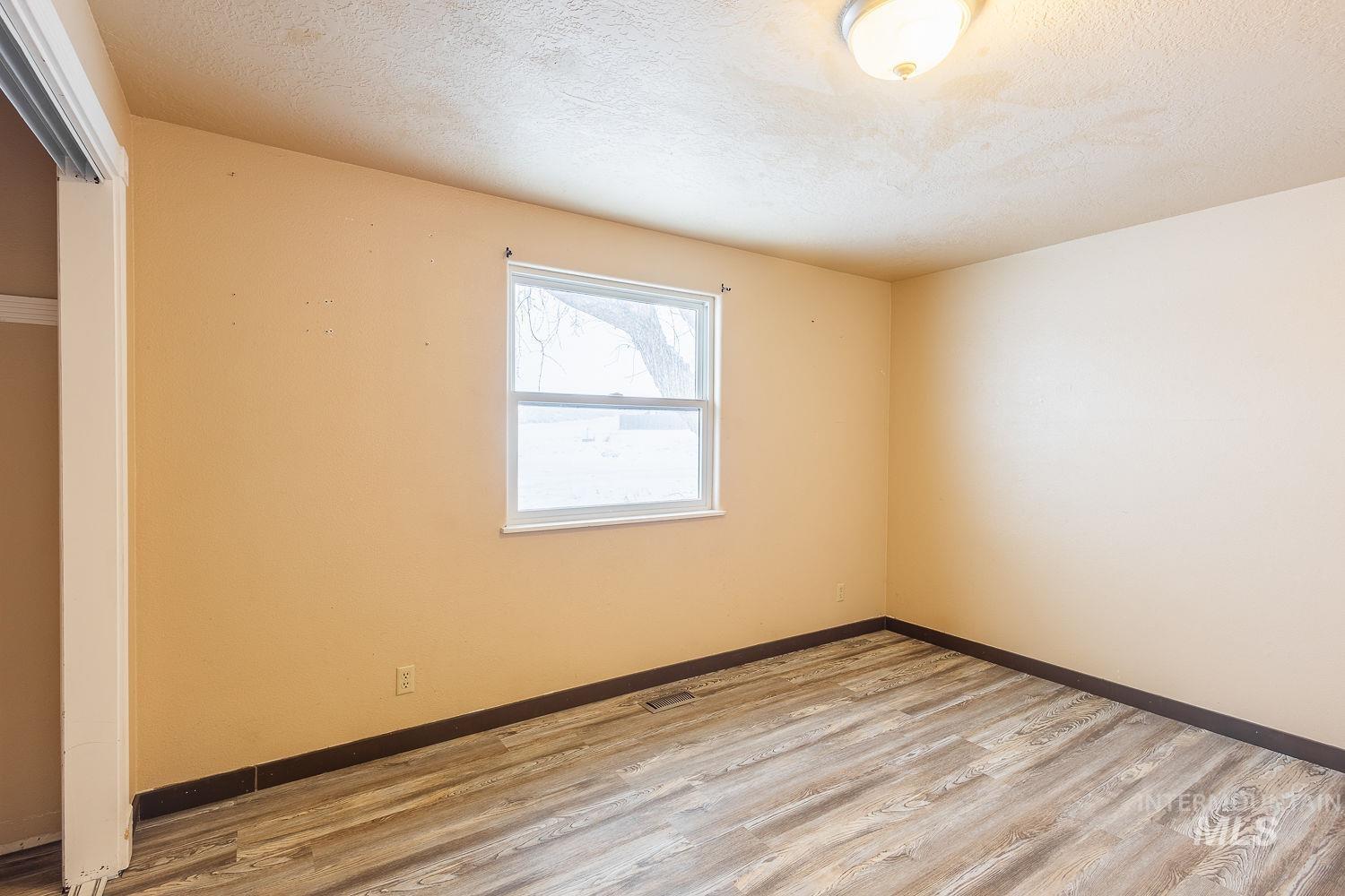 Unfurnished room featuring a textured ceiling and light wood finished floors