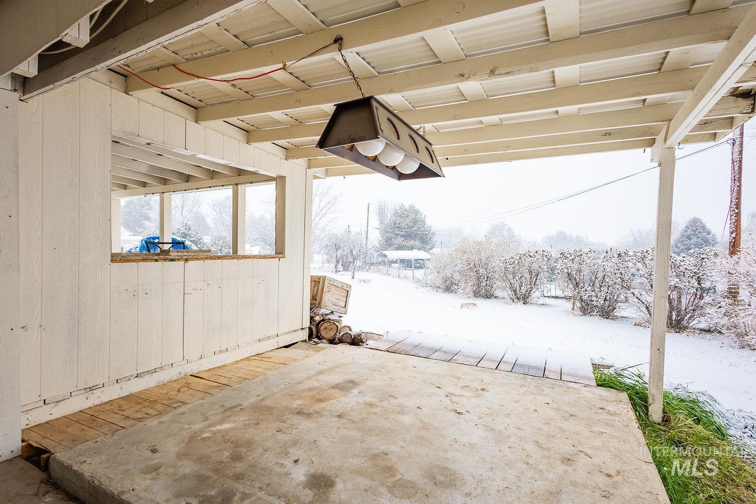 Snow covered patio with a patio and a deck