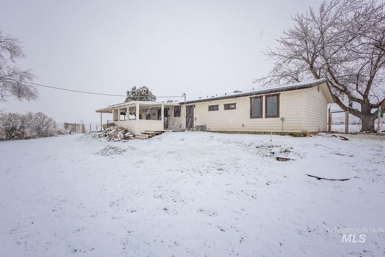 View of snow covered back of property