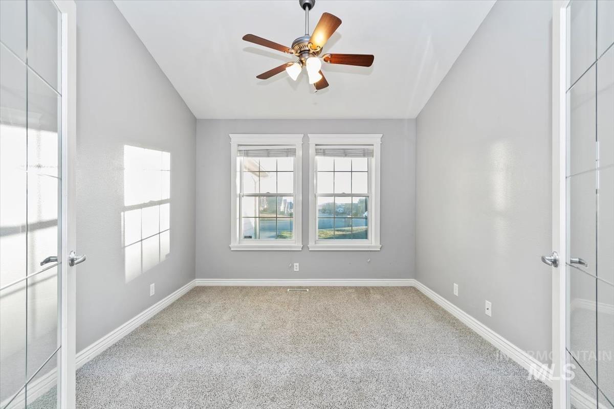 Spare room featuring french doors, light carpet, ceiling fan, and lofted ceiling