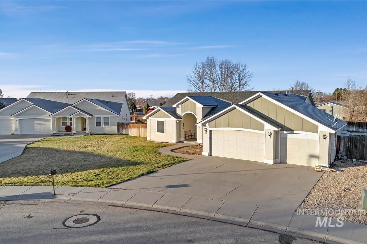 View of front facade featuring driveway, a garage, board and batten siding, and roof with shingles