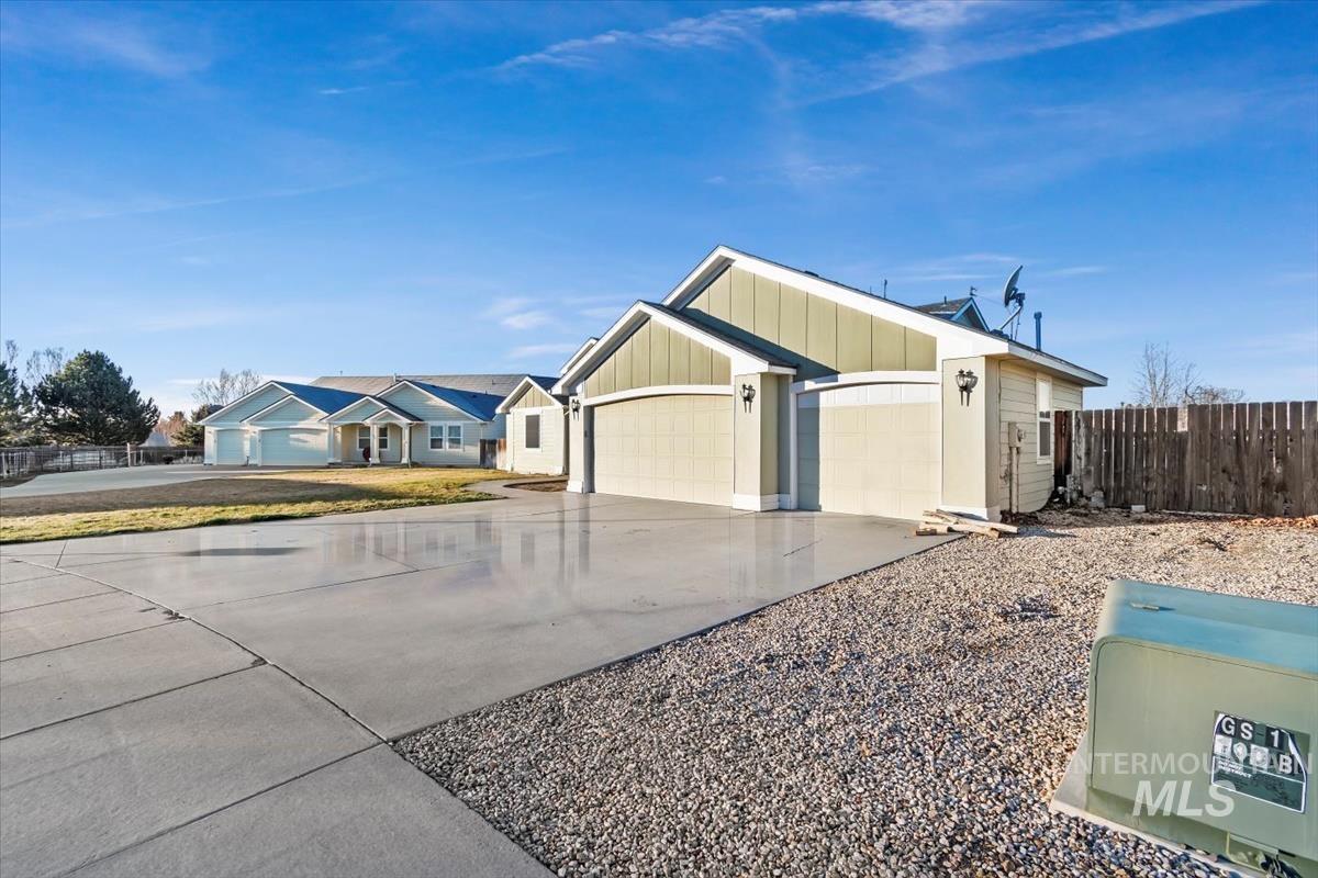 View of front of home with concrete driveway, an attached garage, and board and batten siding
