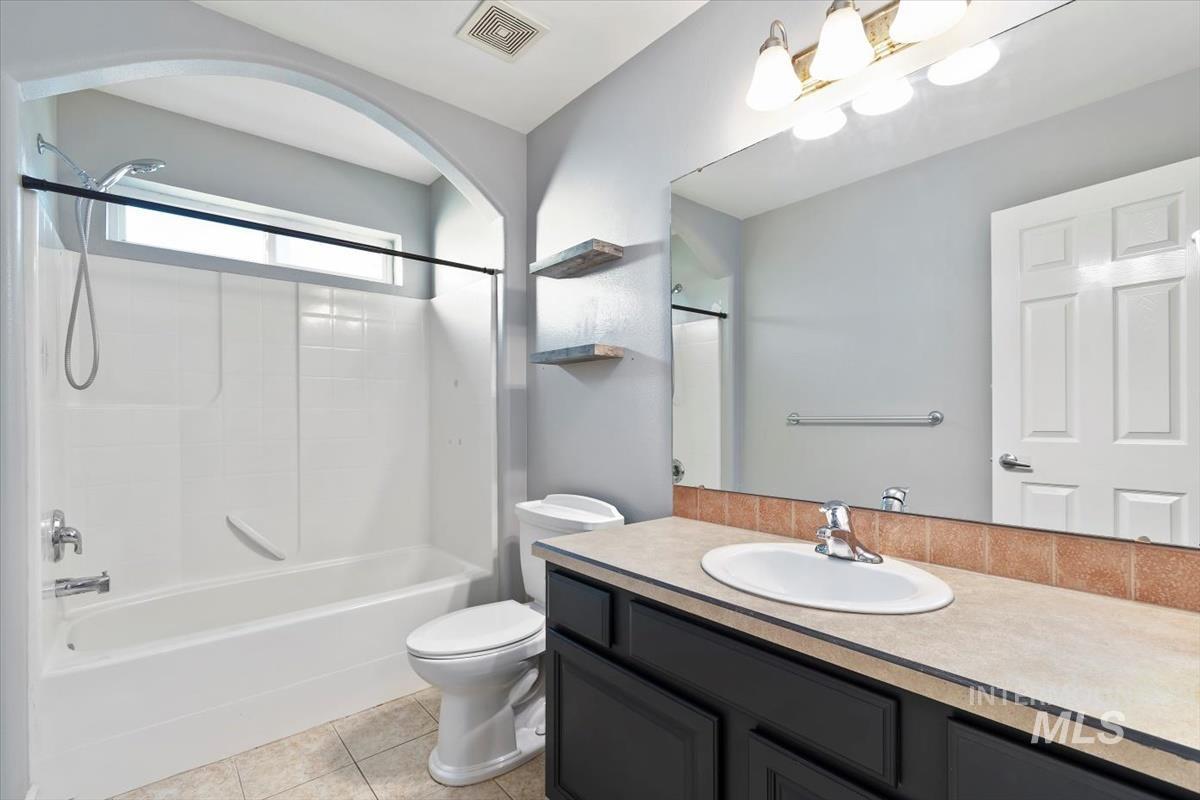 Full bath with vanity, shower / bath combination, and light tile patterned floors