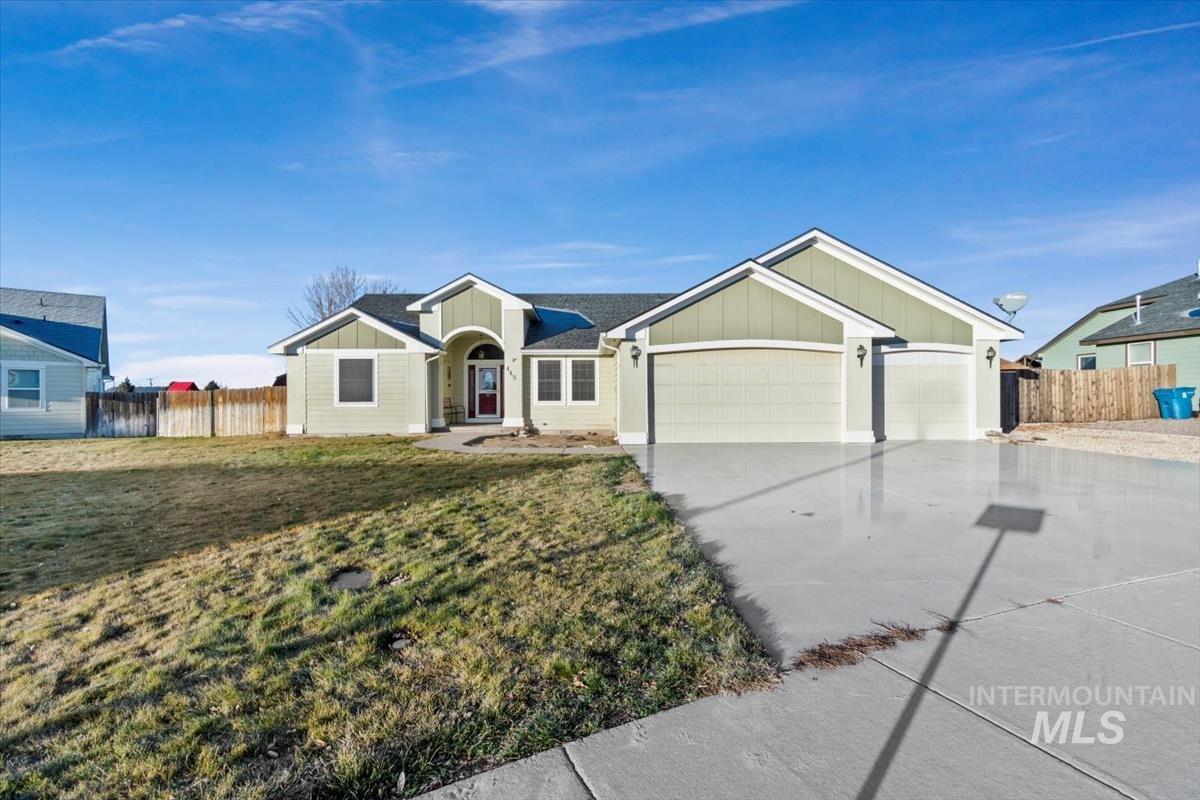 Ranch-style home with concrete driveway, a garage, and board and batten siding