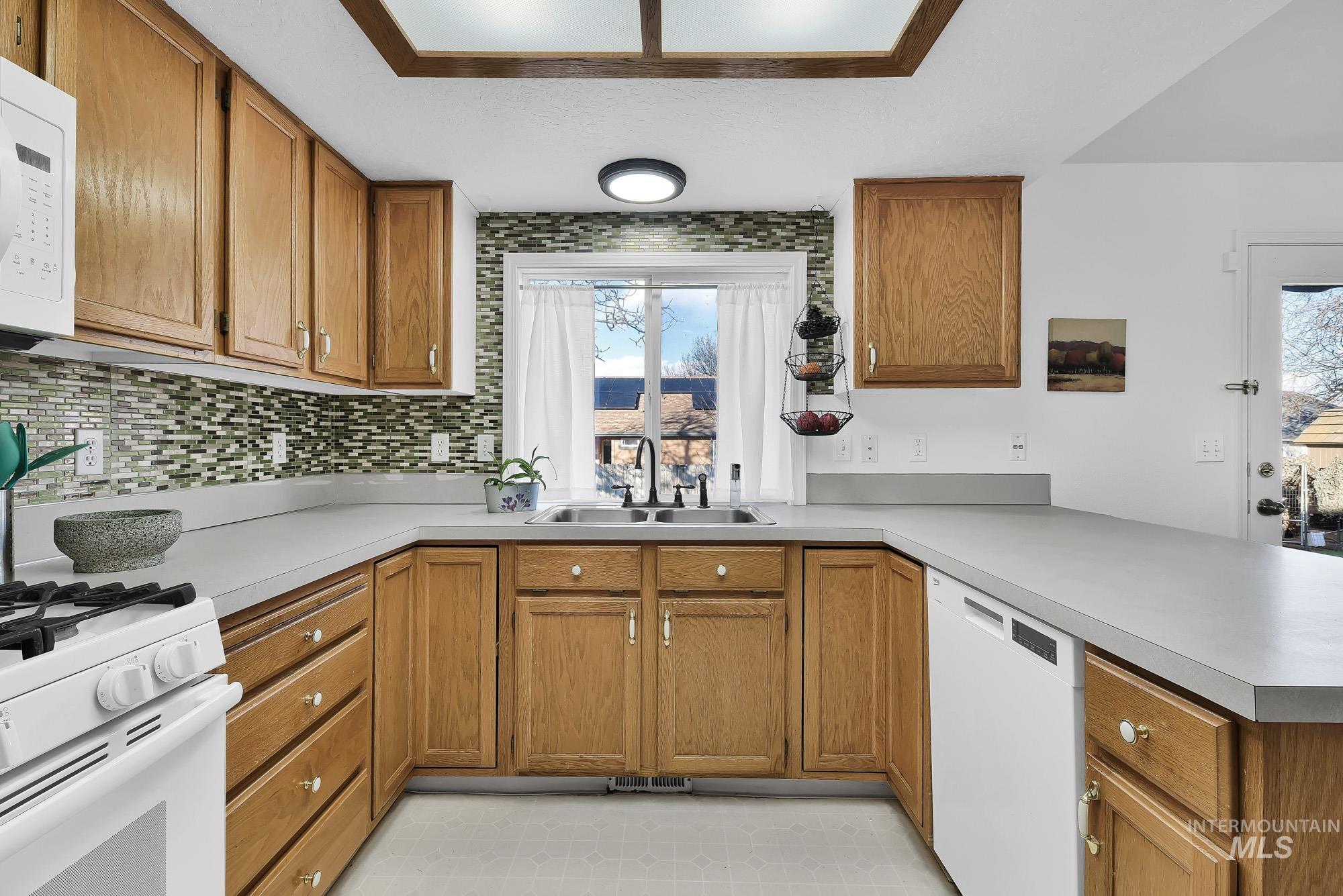 Kitchen featuring brown cabinets and white appliances