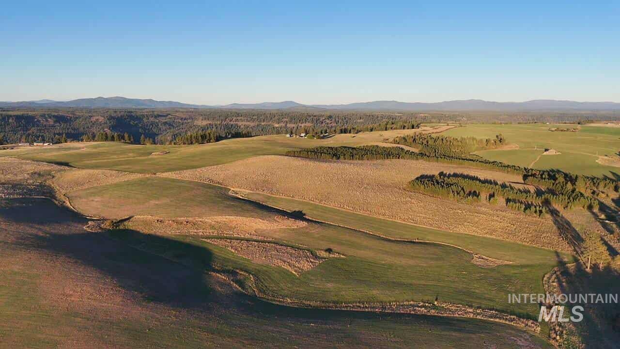 Aerial view of property and surrounding area featuring a mountainous background and a golf club