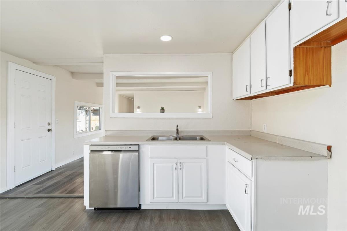 Kitchen featuring white cabinetry, light countertops, dishwasher, dark wood-style floors, and recessed lighting