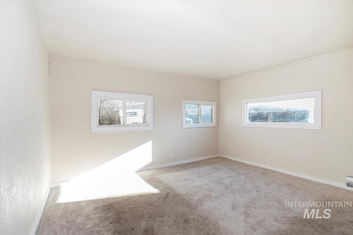 Empty room with carpet floors and baseboards