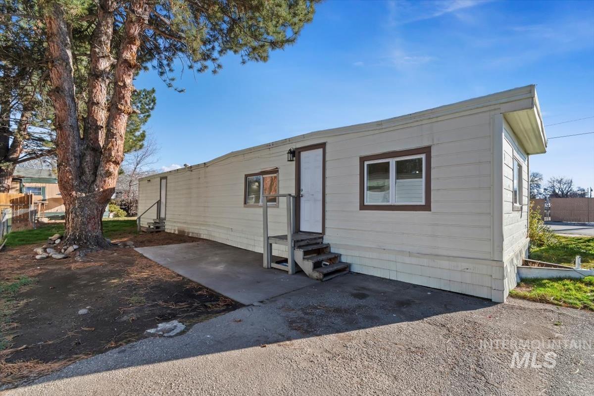 View of front facade with entry steps and a patio area
