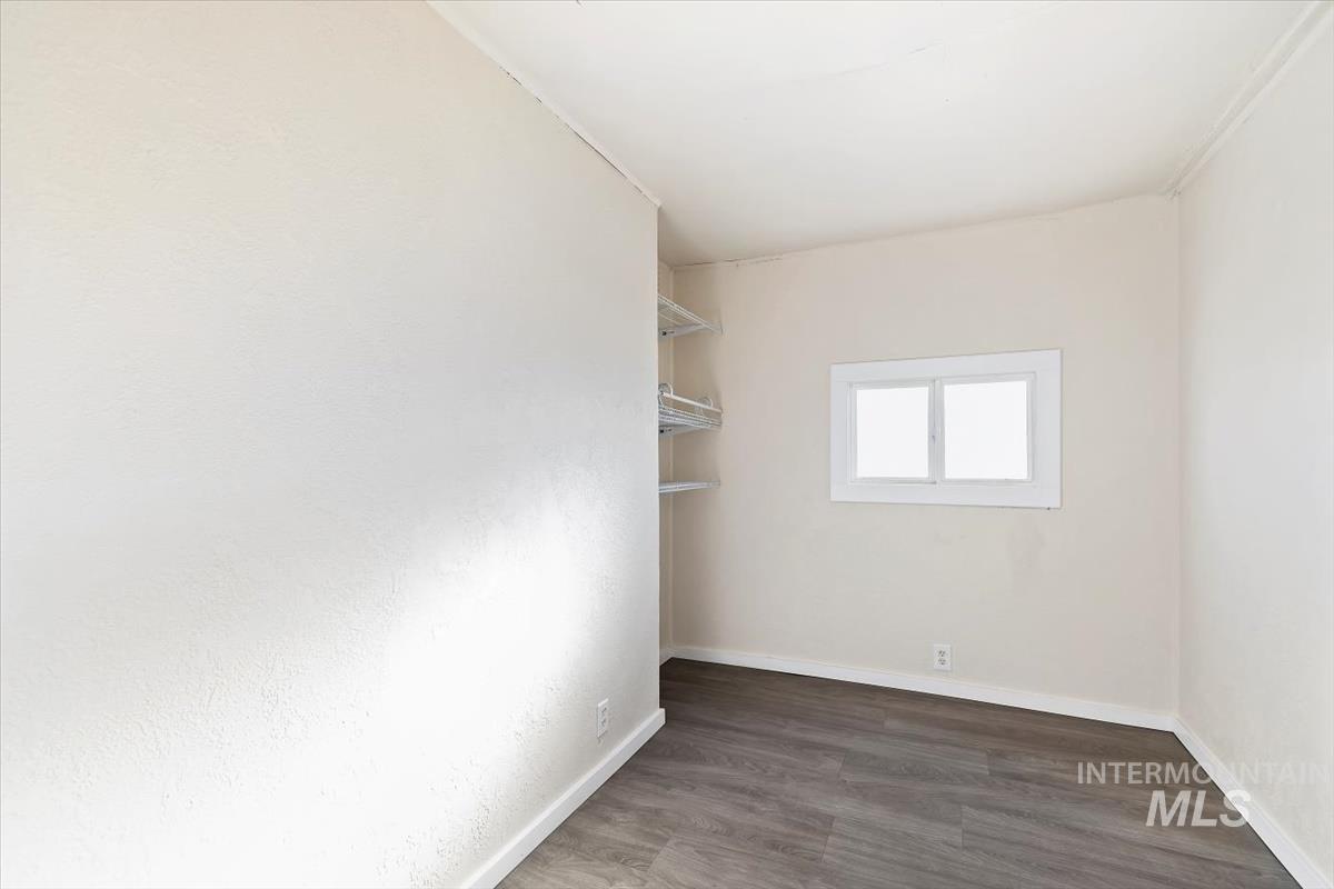 Empty room with dark wood-style floors and baseboards