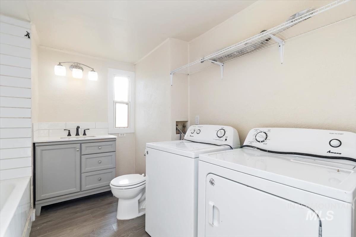 Laundry room with dark wood-style floors and washing machine and dryer