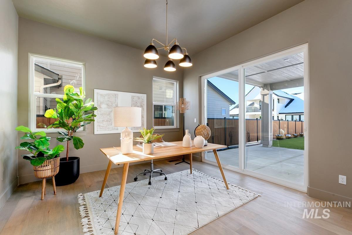 Home office with light wood-style flooring and a chandelier
