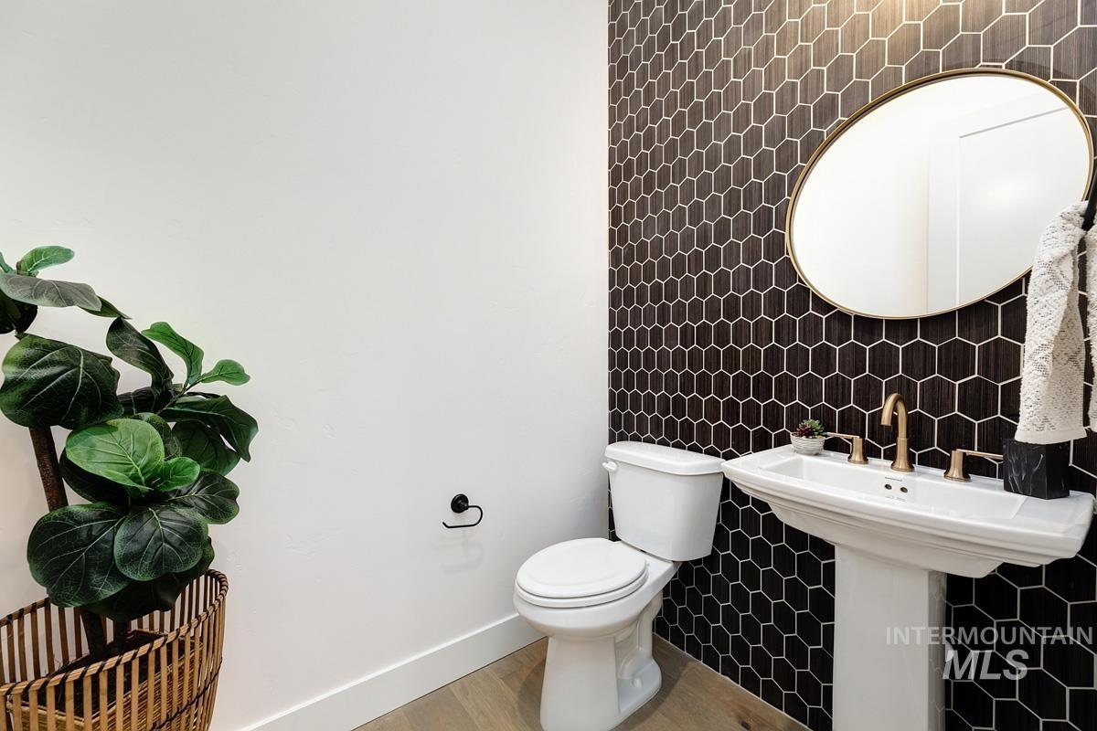 Half bathroom with tile walls and wood finished floors
