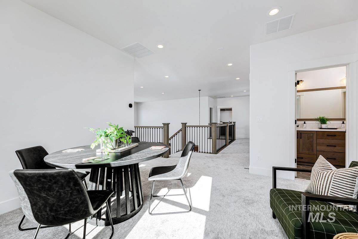 Dining area with light colored carpet and recessed lighting