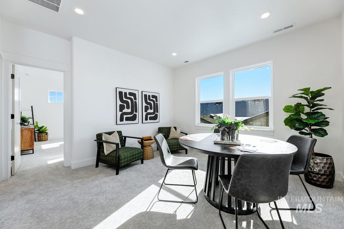 Dining room with light carpet and recessed lighting