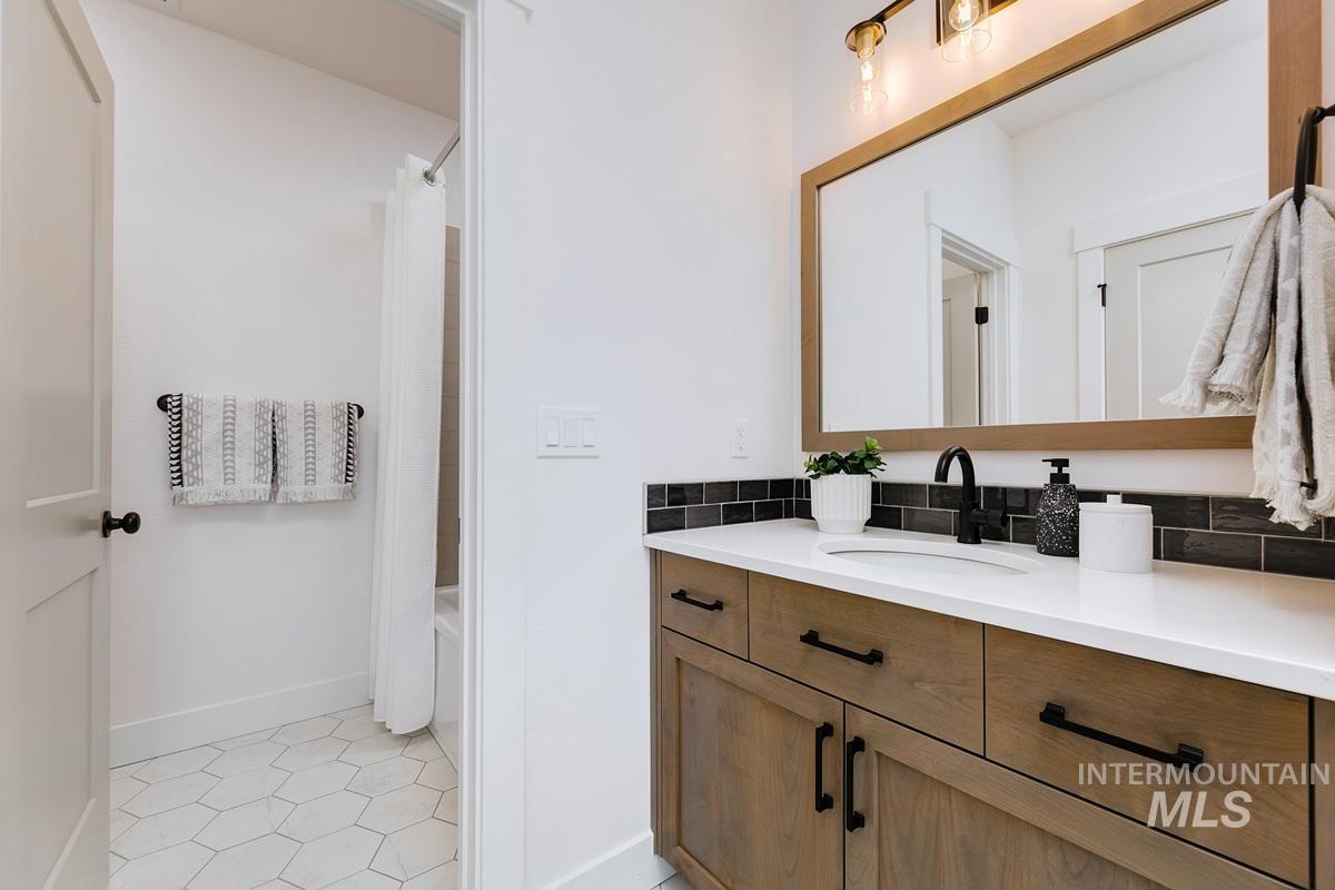 Bathroom featuring vanity, light tile patterned floors, and shower / bath combo