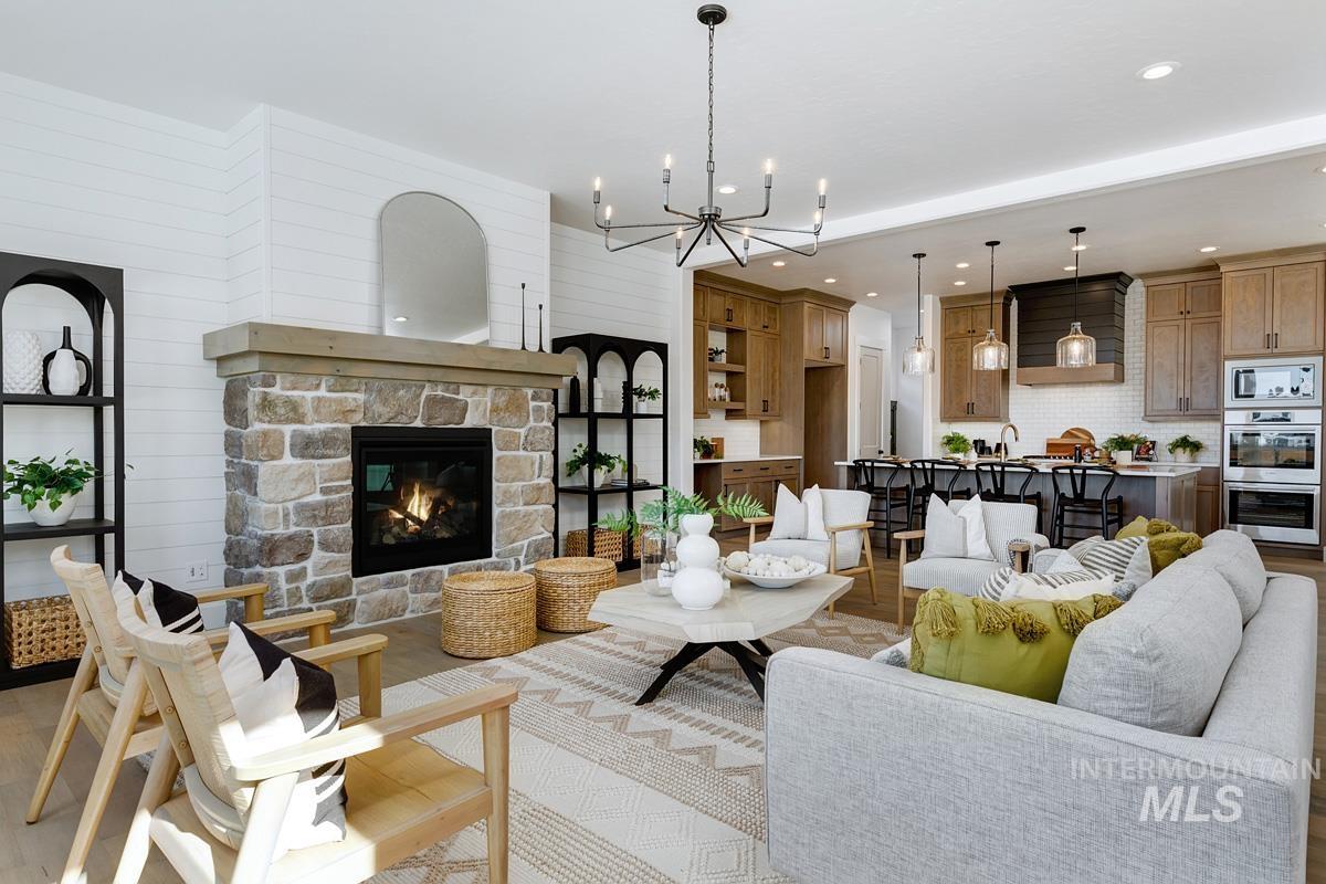 Living room featuring a fireplace, a chandelier, recessed lighting, wooden walls, and wood finished floors