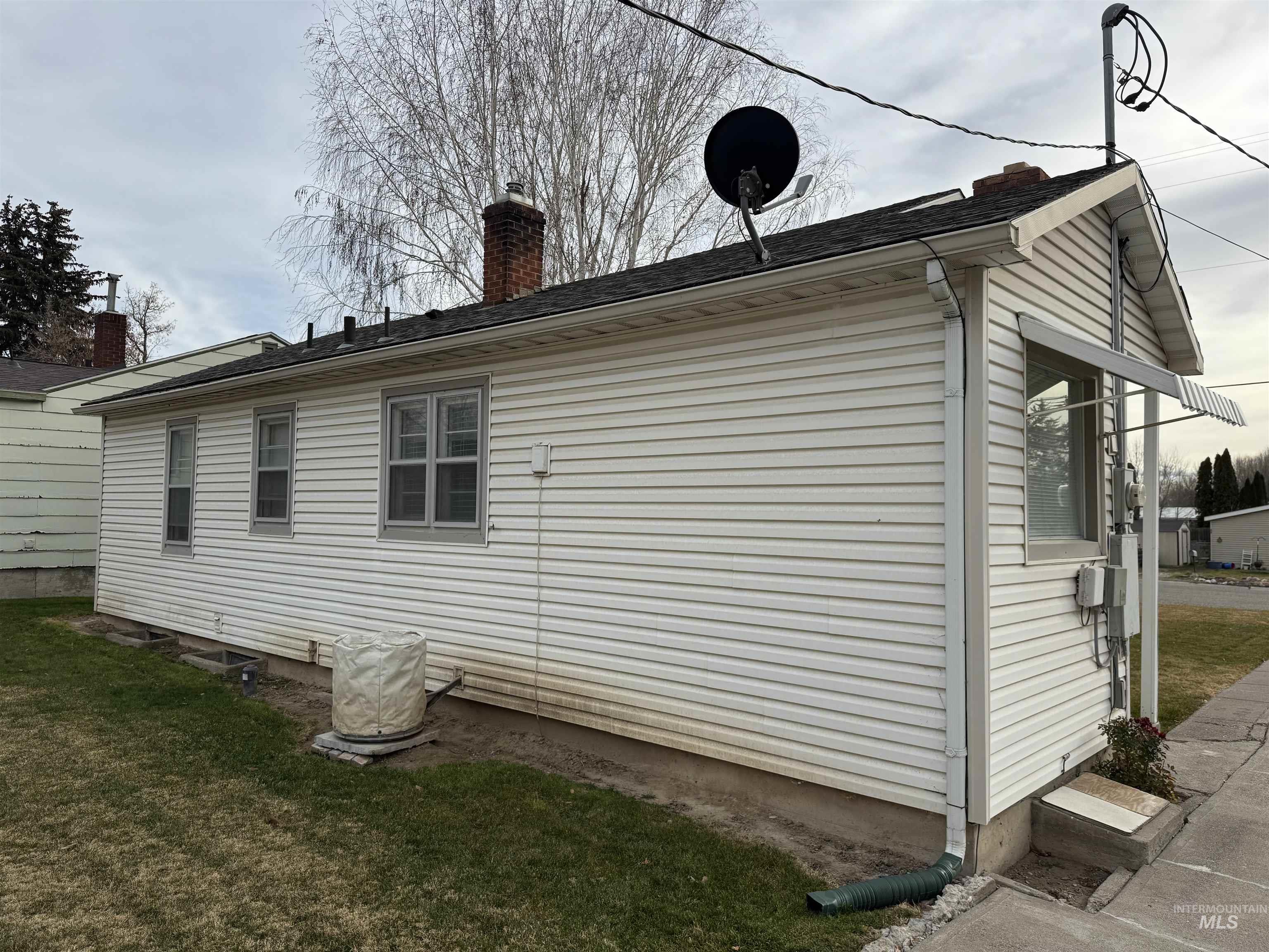 View of home's exterior with a yard and a chimney