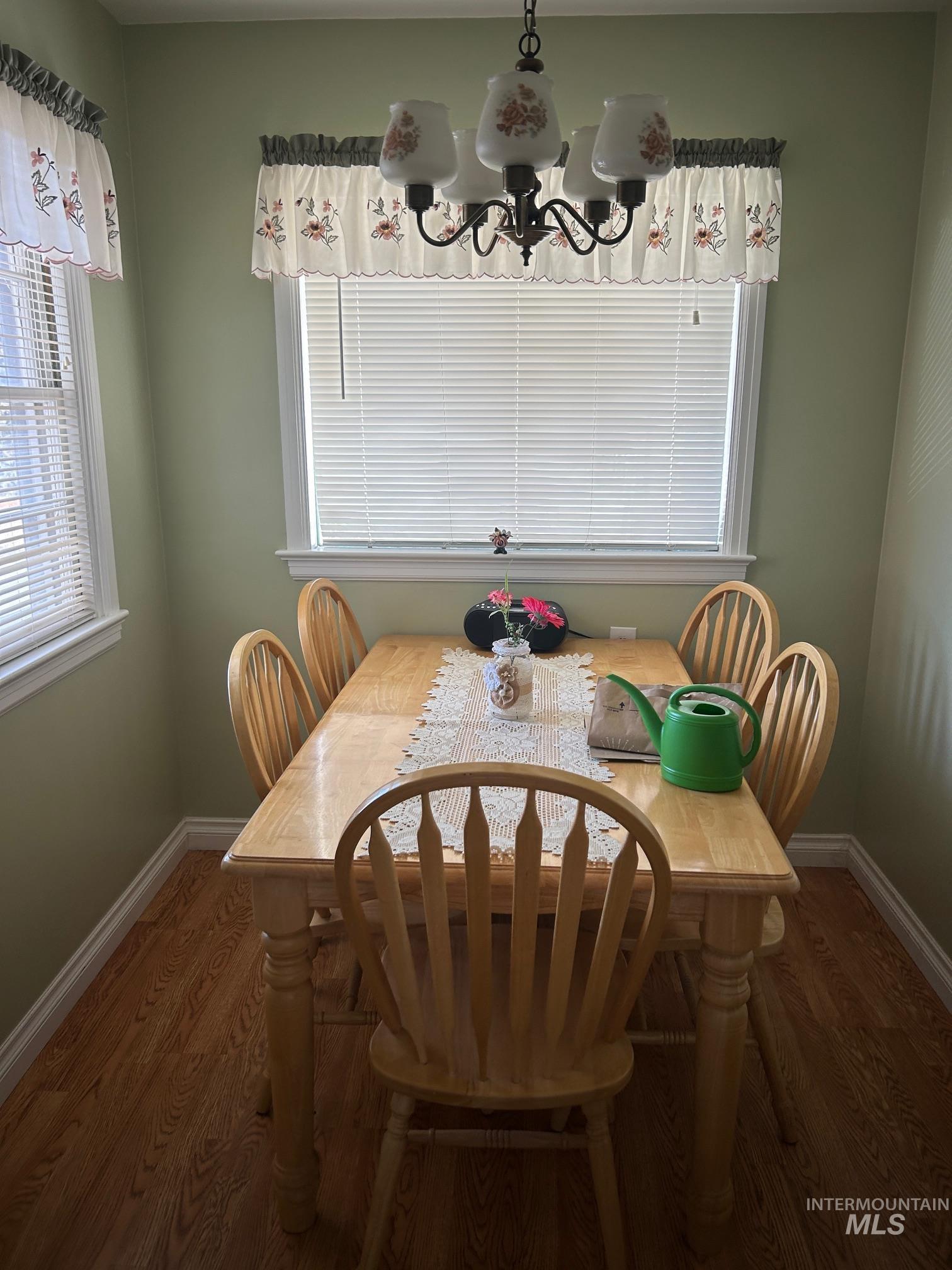 Dining area with dark wood finished floors and a chandelier