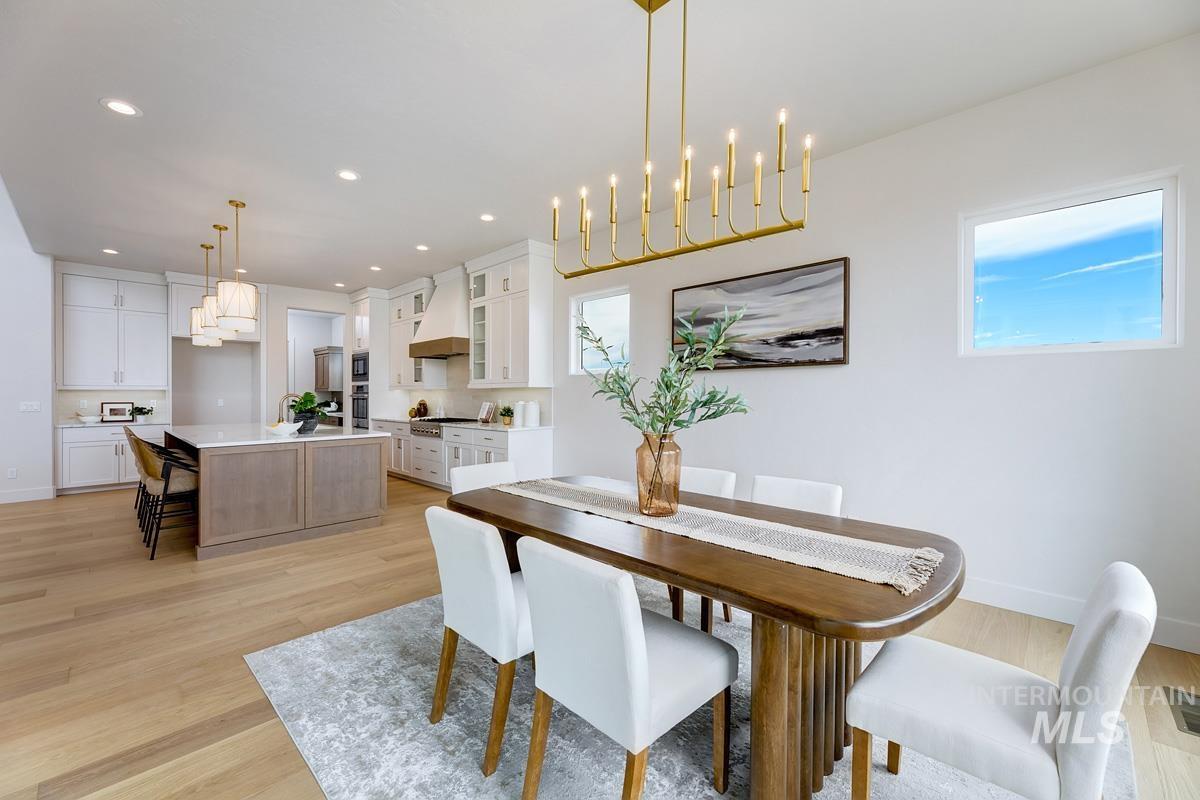 Dining room with light wood-type flooring, a chandelier, and recessed lighting
