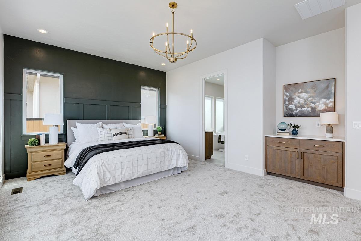 Bedroom featuring a chandelier, light carpet, a decorative wall, and recessed lighting