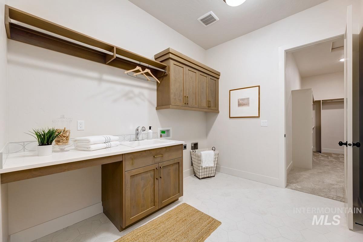 Washroom featuring hookup for a washing machine and cabinet space