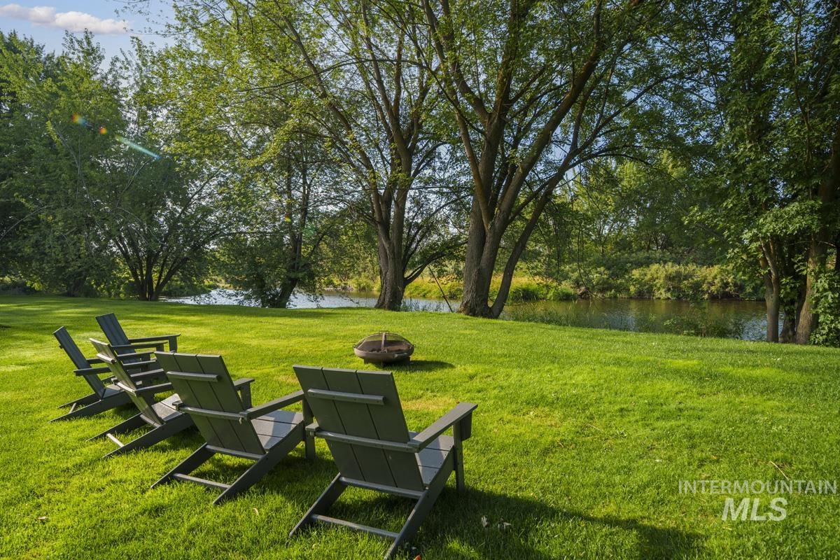 Surrounding community featuring a water view, a lawn, and a fire pit