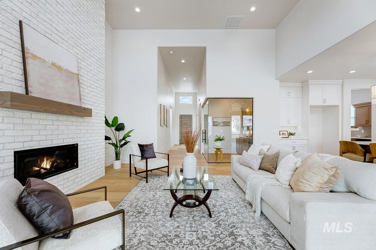 Living room featuring light wood-type flooring, a brick fireplace, and recessed lighting