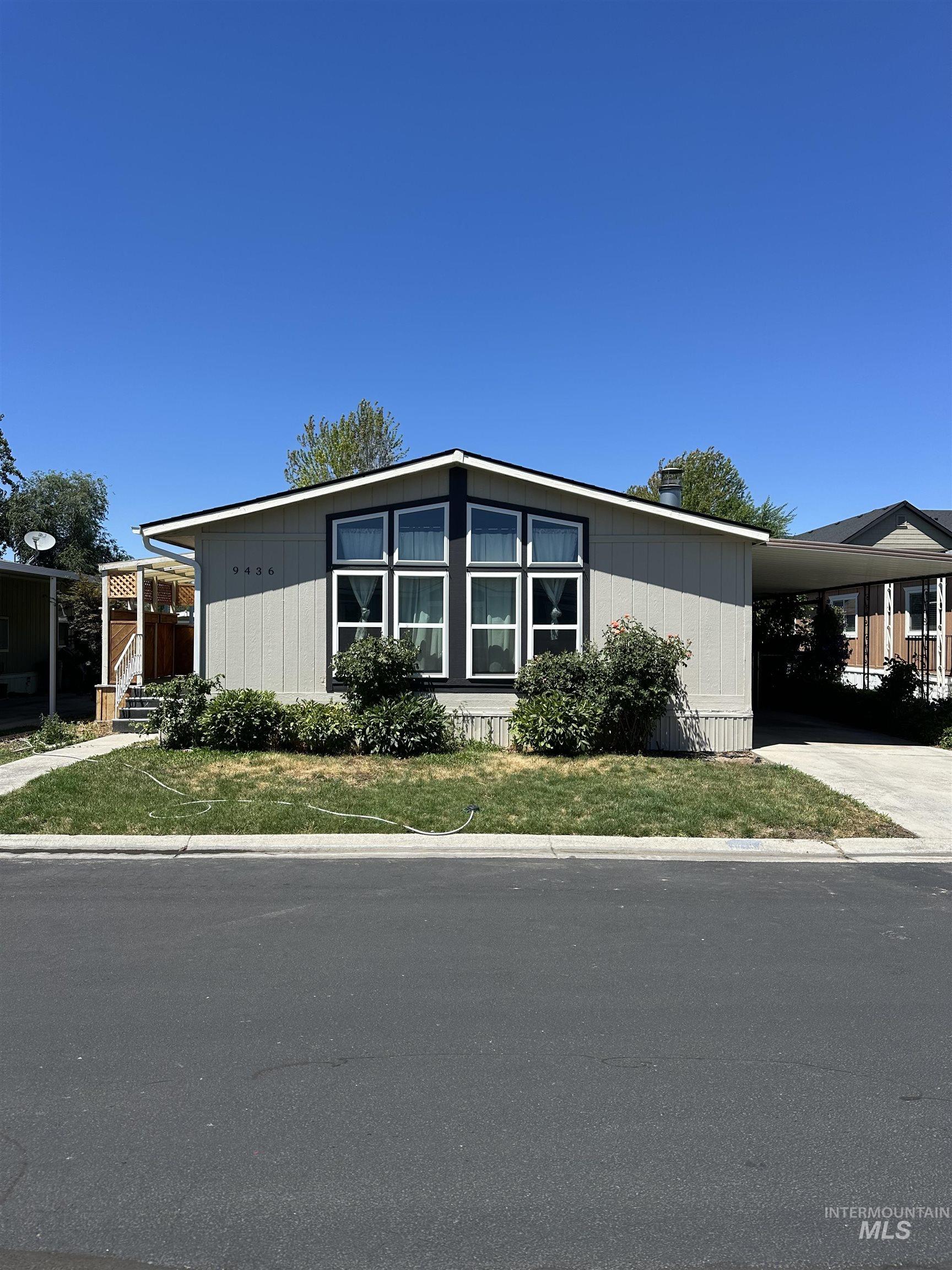 View of front of home featuring a carport, a front yard, and driveway