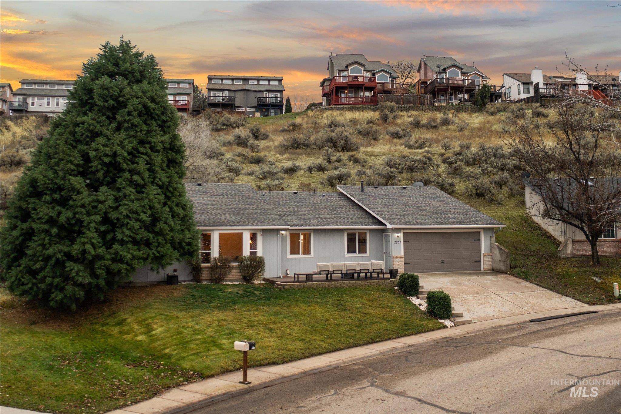 View of front of home with roof with shingles, concrete driveway, a front yard, a garage, and a residential view