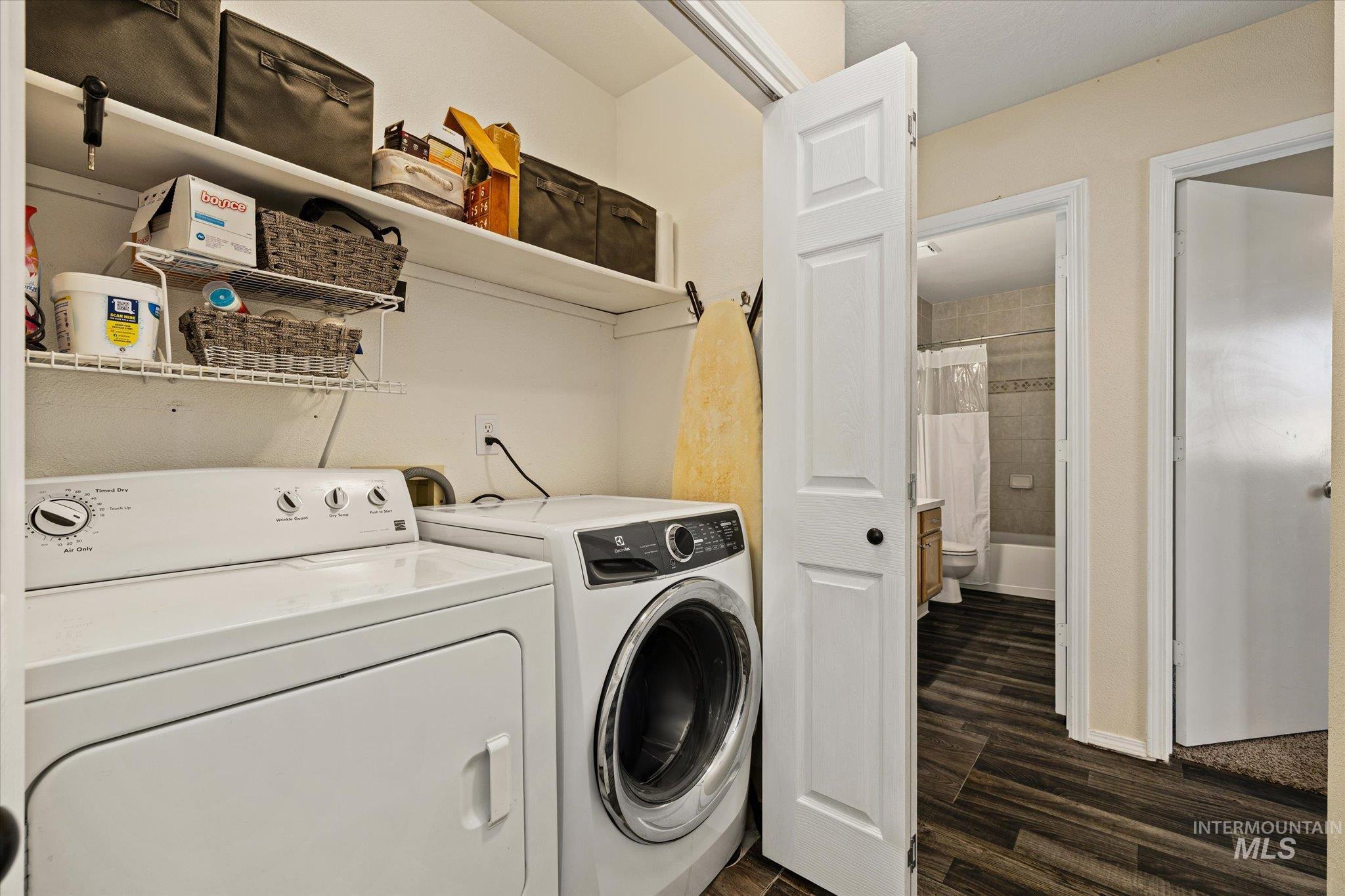 Laundry area featuring dark wood-type flooring and separate washer and dryer