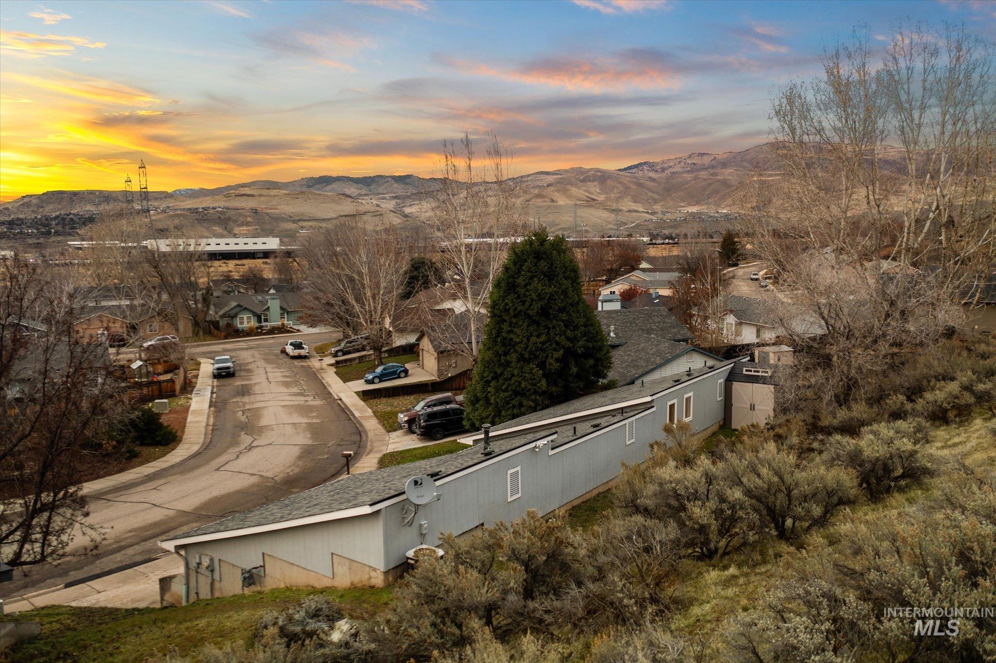 Aerial overview of property's location with a mountainous background and nearby suburban area
